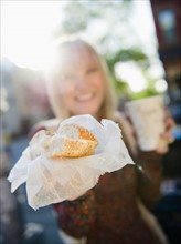 USA, Brooklyn, Williamsburg, Woman showing bagel. Photo : Jamie Grill