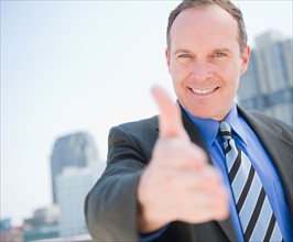 USA, New Jersey, Jersey City, Businessman showing thumbs up. Photo: Jamie Grill