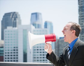USA, New Jersey, Jersey City, Businessman shouting through megaphone. Photo : Jamie Grill