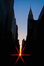 USA, New York, Manhattan, City buildings at sunset with sunbeam. Photo: Daniel Grill