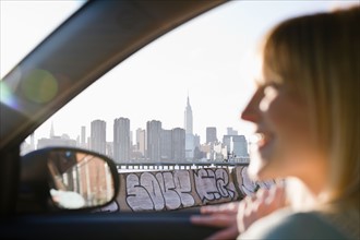 USA, Brooklyn, Williamsburg, Woman driving through city. Photo : Jamie Grill