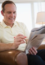 Man reading job adverts in newspaper. Photo: Jamie Grill