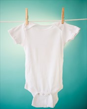 Close up of baby clothes hanging on clothesline. Photo : Jamie Grill