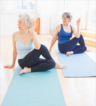 Two senior women practicing yoga. Photo : Daniel Grill