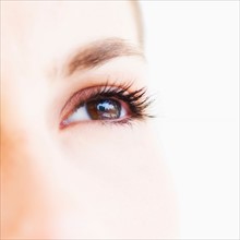 Studio shot of young woman, close-up of eye.