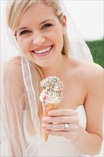 Portrait of young bride eating ice cream. Photo : Jamie Grill
