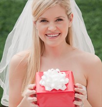 Happy bride holding red box. Photo: Jamie Grill