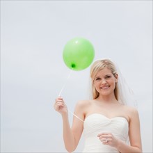 Happy bride holding green balloon. Photo: Jamie Grill