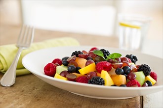 Fresh fruit salad in bowl on table.