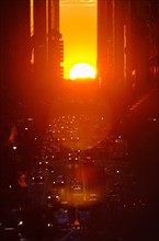 USA, New York, New York City, Sunset illuminating busy street.
