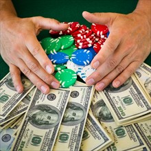 Hands grabbing gambling chips and money.