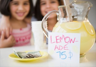 Close up of two girl's (8-9, 10-11) selling lemonade. Photo: Jamie Grill