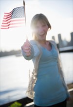 USA, Brooklyn, Williamsburg, Woman holding American flag. Photo: Jamie Grill