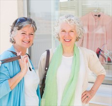 Two senior women standing in front of window display. Photo : Daniel Grill