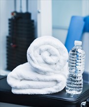 Close up of towel and bottle in gym. Photo : Daniel Grill
