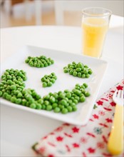 Close up of smiley on plate made of green peas. Photo: Jamie Grill