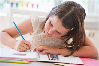 Close up of girl (6-7) drawing in notebook. Photo : Daniel Grill