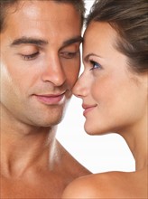 Studio portrait of young attractive couple looking at each other. Photo: momentimages
