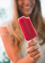 Close up of woman holding popsicle. Photo: Jamie Grill