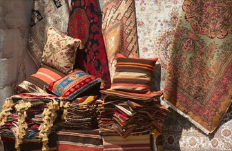 Turkey, Istanbul, Grand Bazaar, rugs and cushions for sale.