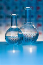 Beakers with periodic tables in laboratory.