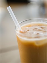 Close up of glass of iced coffee with straw. Photo : Jamie Grill