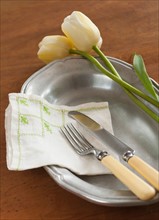Tulips on plate with cutlery.