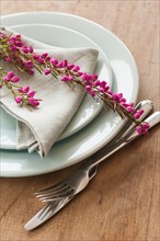 Flowers on plate with cutlery and napkin.
