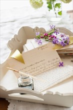 Quill pen with letters and flowers.