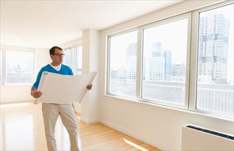 Architect reading blueprint in new office.