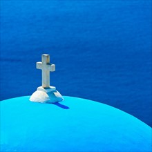Greece, Cyclades Islands, Santorini, Oia, Church dome with cross by sea.