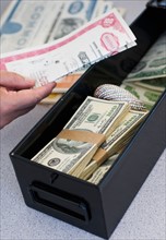 Hand inserting valuables into safe deposit box.
