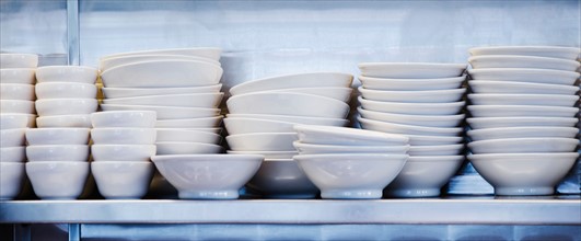 Stacked plates and bowls in kitchen.