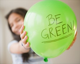 Close up of girl (10-11) with green balloon. Photo : Jamie Grill