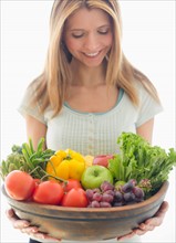 Woman holding bowl of organic fruit and vegetables.