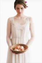 Young woman carrying basket of eggs.