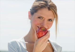 Portrait of woman eating apple.