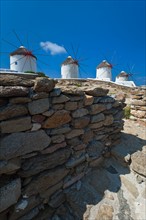 Greece, Cyclades Islands, Mykonos, Stone wall near old windmills.