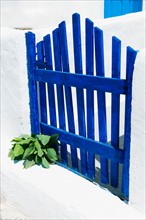 Greece, Cyclades Islands, Santorini, Oia, Blue fence outside house.