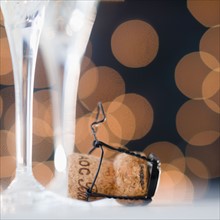 Close up of champagne flutes and cork. Photo : Jamie Grill