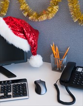 Close up of Santa hat and Christmas decorations on office desk. Photo: Daniel Grill