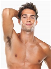 Studio portrait of young muscular man with hand in hair. Photo : momentimages