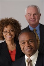 Portrait of three business people, studio shot. Photo : Rob Lewine