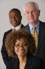 Portrait of three business people, studio shot. Photo : Rob Lewine