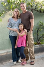 Pregnant mother, father and daughter (6-7) posing for portrait. Photo: Rob Lewine