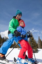 USA, Colorado, Telluride, Father with son (8-9) skiing together. Photo : db2stock