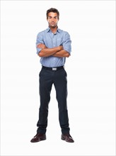 Studio shot of confident business man standing with hands folded. Photo : momentimages