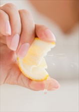 Close up of woman's hand squeezing lemon. Photo : Jamie Grill