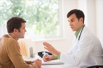 Man receiving advice from doctor in office.