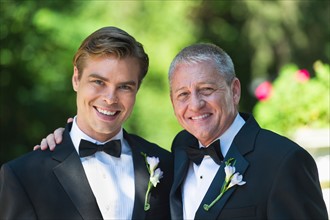Portrait of father with bridegroom at wedding.